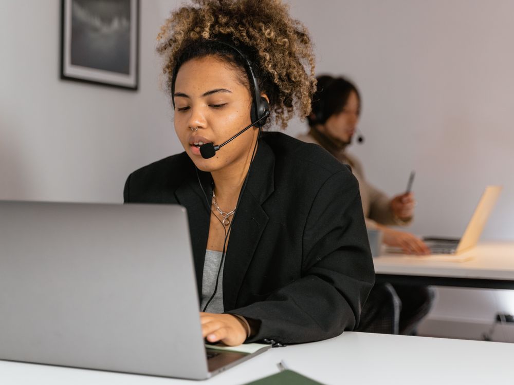 Standardiste avec casque téléphonique gérant un appel en anglais à l'accueil d'une entreprise