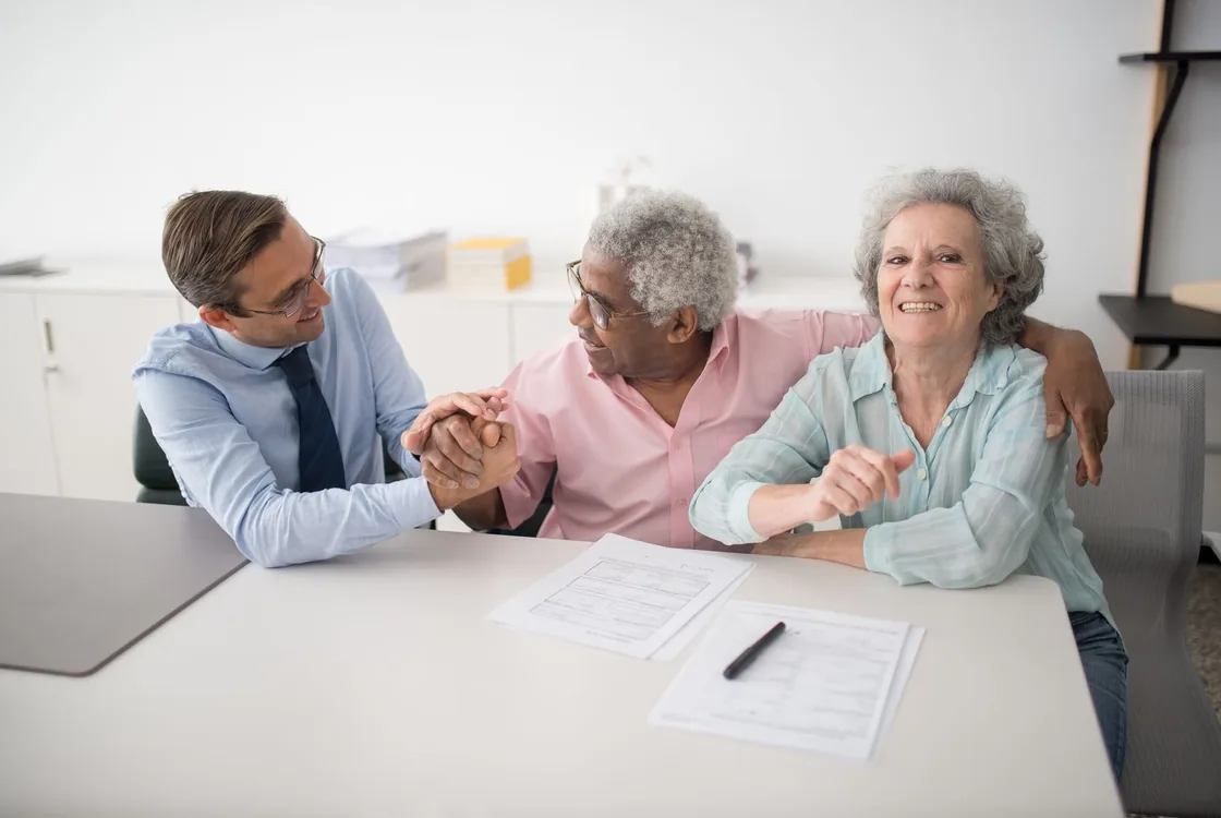 Conseiller en assurance recevant un couple de clients pour presenter un contrat, formation anglais assurance Cabinet Action