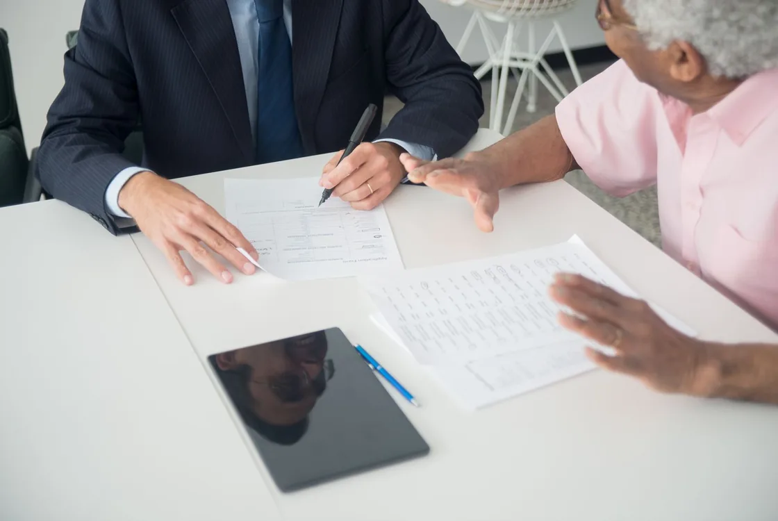 Conseiller assurance expliquant les garanties d'un contrat a un client senior, mise en situation en anglais