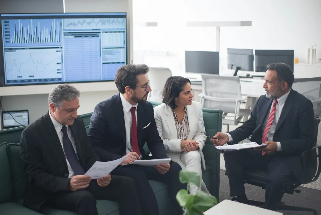 Equipe en salle de marches devant des ecrans de cotation, anglais de la finance et de l'investissement