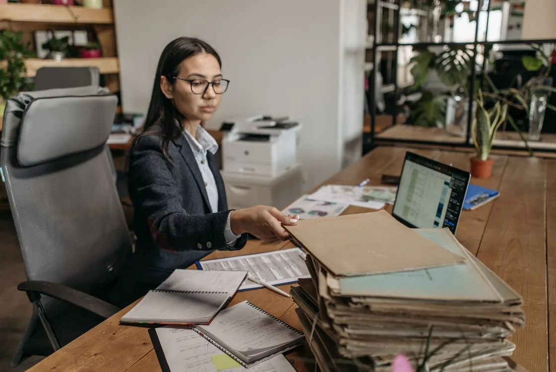 Comptable classant des dossiers clients a son bureau, formation anglais comptable Cabinet Action