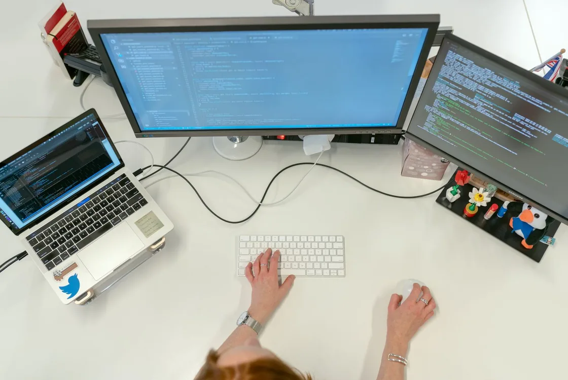 Poste de developpement avec code affiche sur plusieurs ecrans, vocabulaire anglais du logiciel