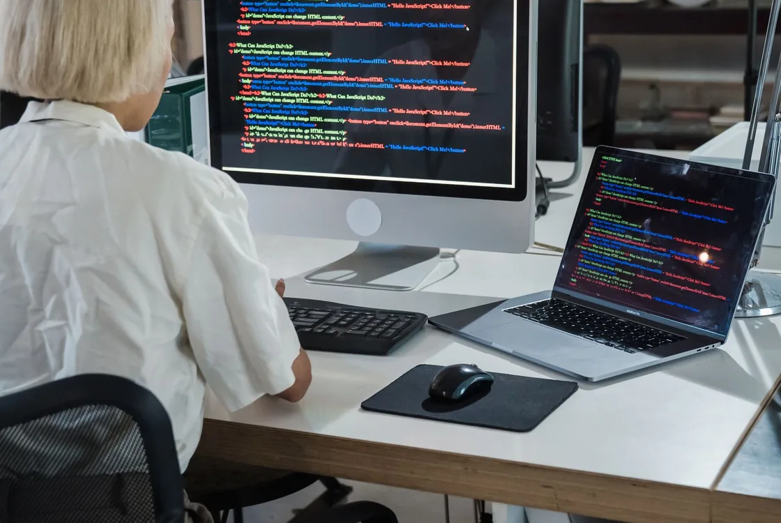 Ingenieure logiciel en revue de code devant ses ecrans, anglais de la documentation technique