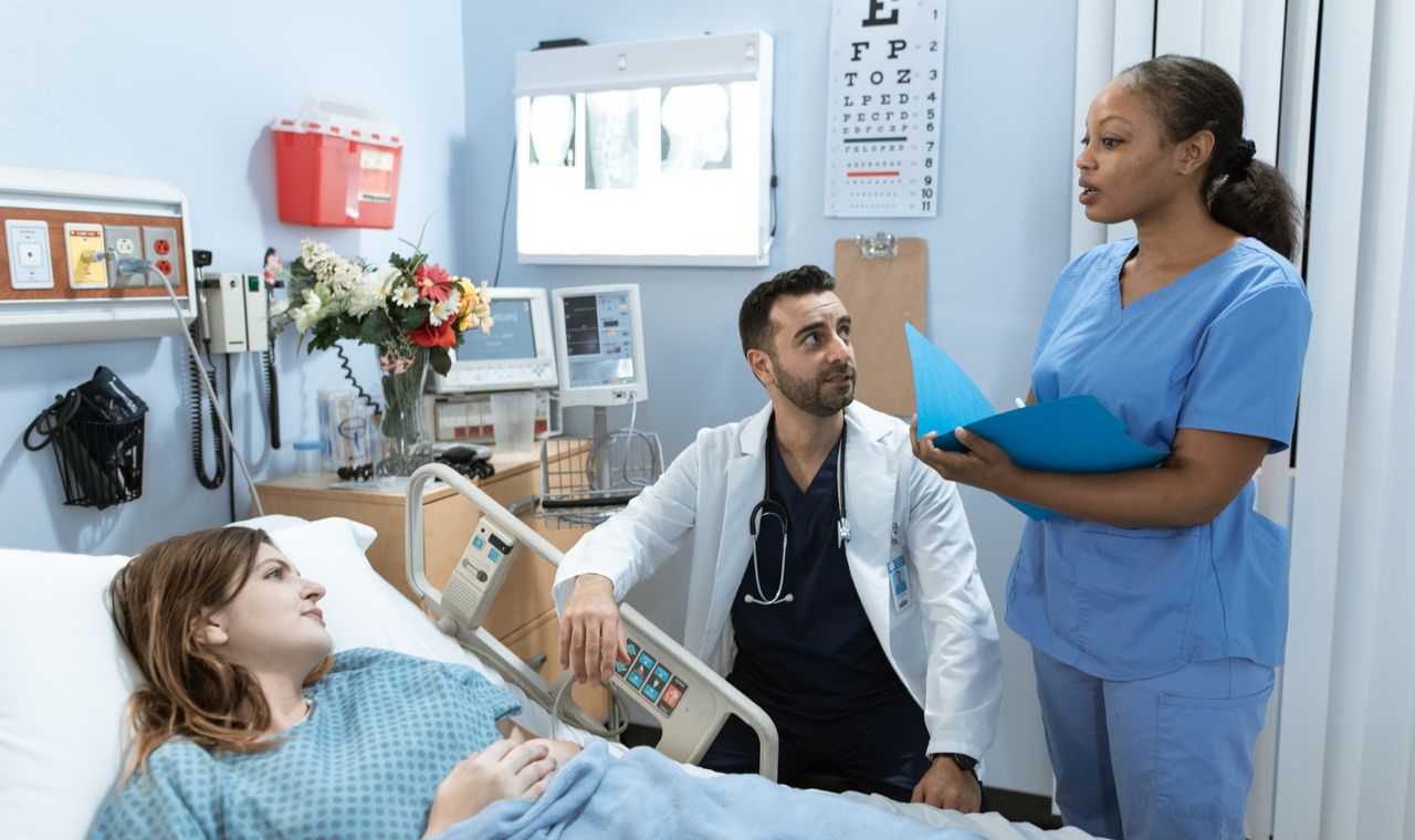 Médecin et infirmière échangeant au chevet d'un patient à l'hôpital, formation anglais médical Cabinet Action