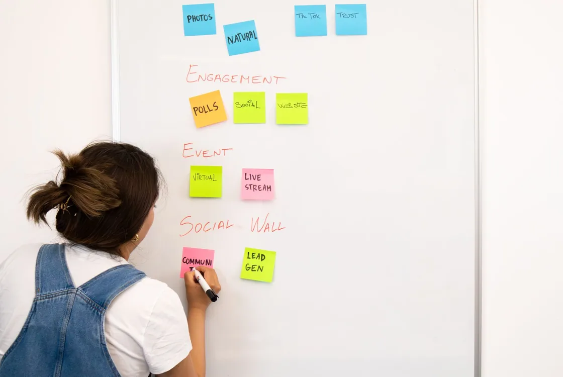 Cheffe de projet ecrivant un plan editorial en anglais au tableau, lexique engagement et lead generation