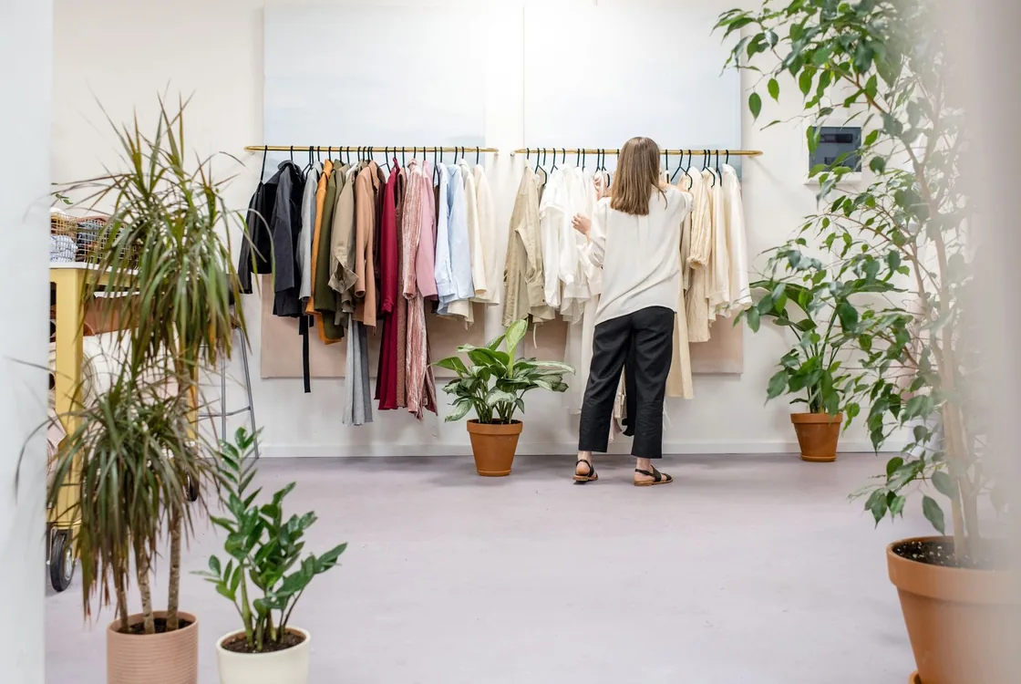 Vendeuse organisant la collection dans une boutique lumineuse, anglais de la vente et du conseil client